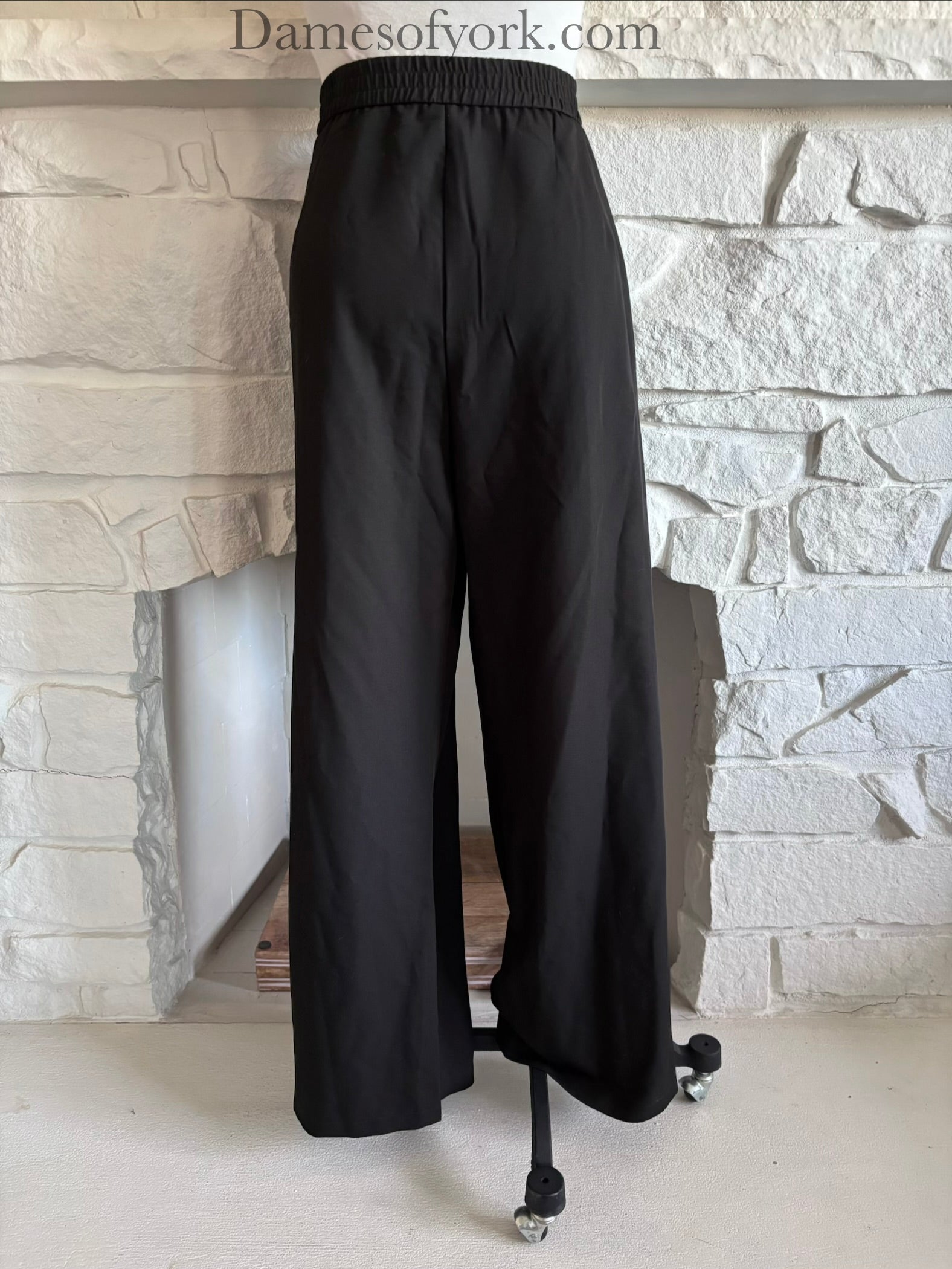 Back view of black wide leg trousers on mannequin with clean tailored fit