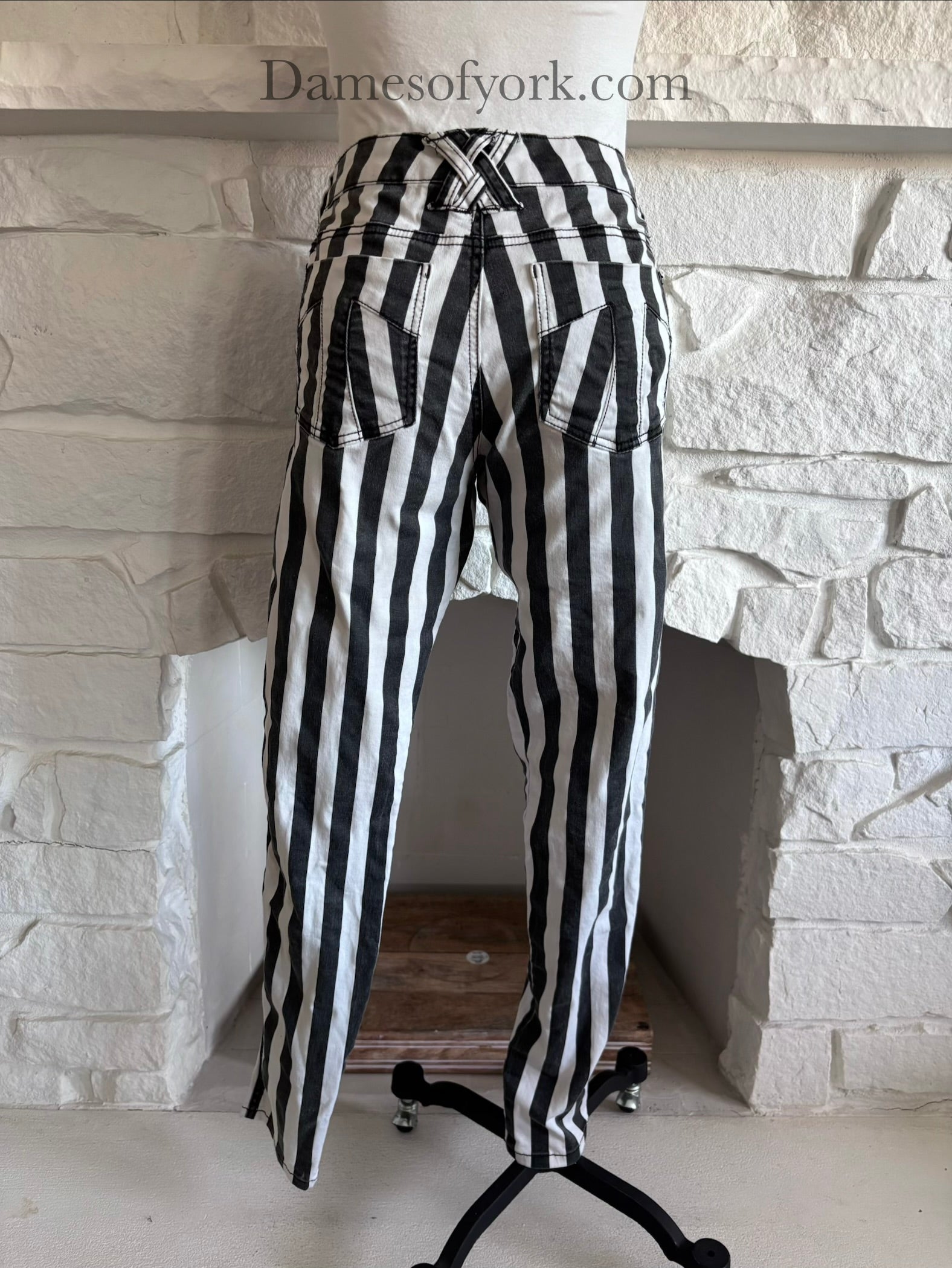 Back view of striped skinny jeans on mannequin showing stitched back pocket details view of black and white vertical striped skinny jeans on mannequin