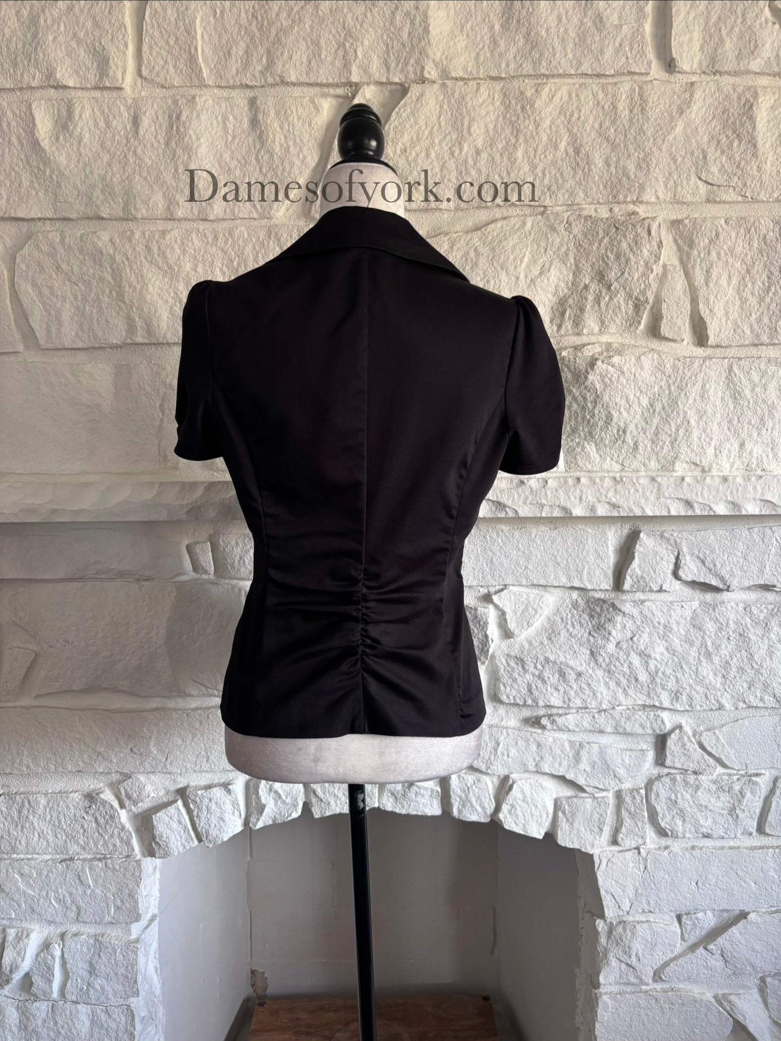 Back view of short sleeve corporate goth blazer on mannequin