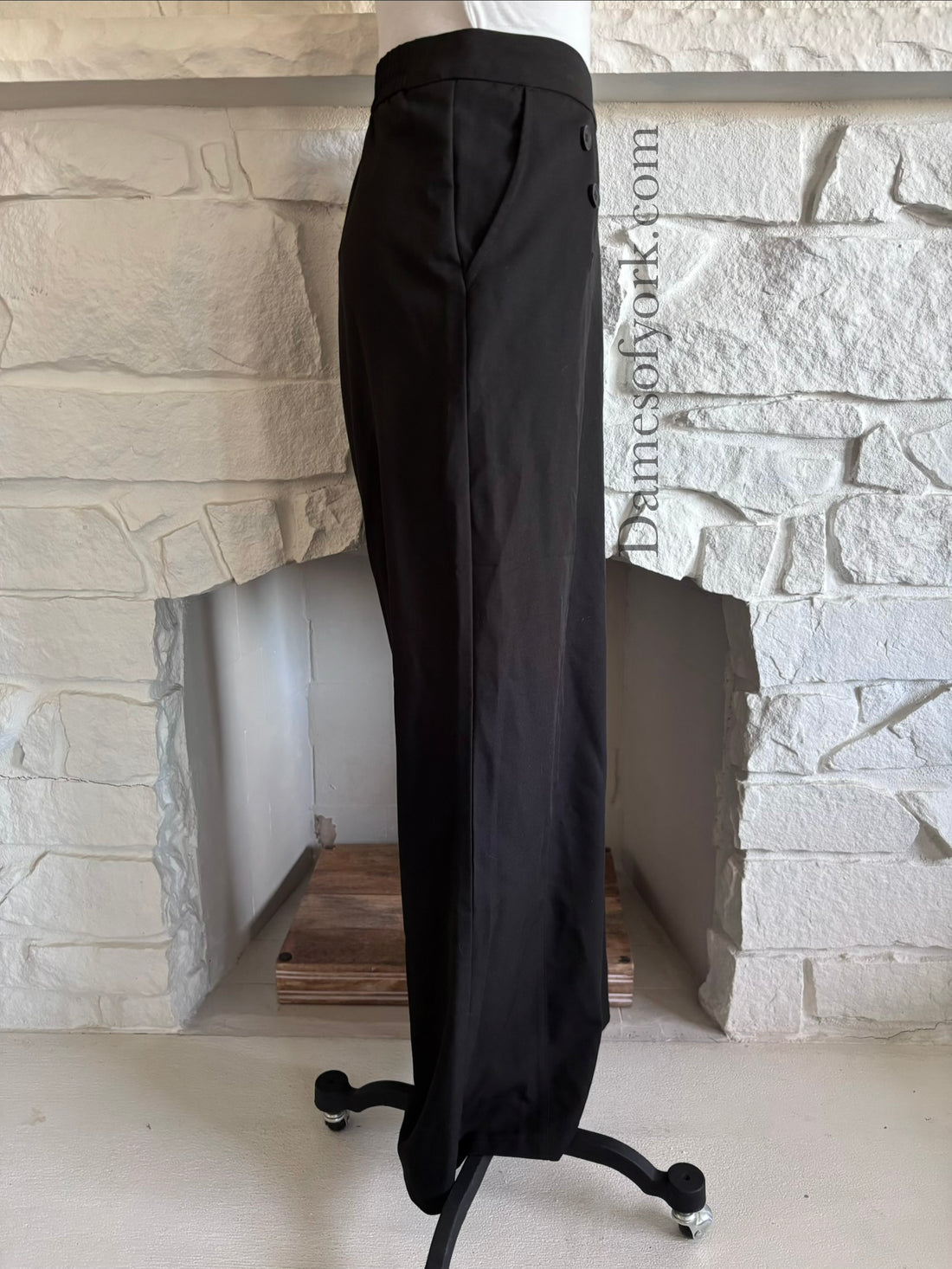 Side view of black corporate goth pants on mannequin with structured waistband and pockets