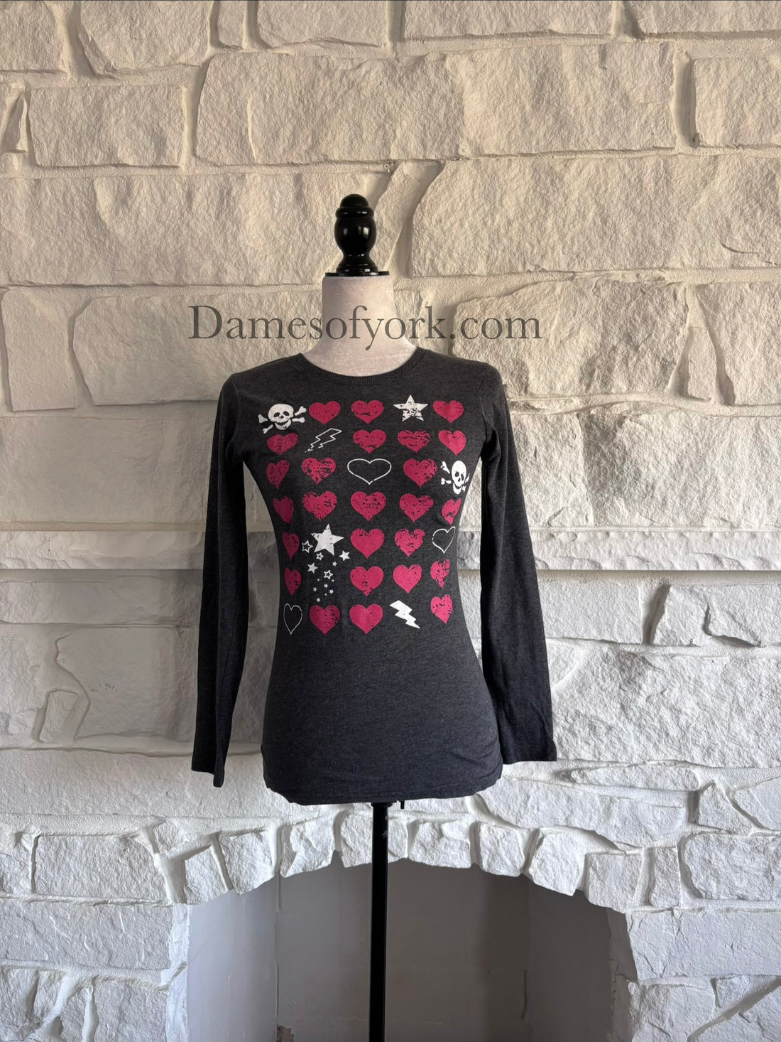 Front view of grey long sleeve graphic t-shirt on mannequin with heart, skull and lightning bolt print.