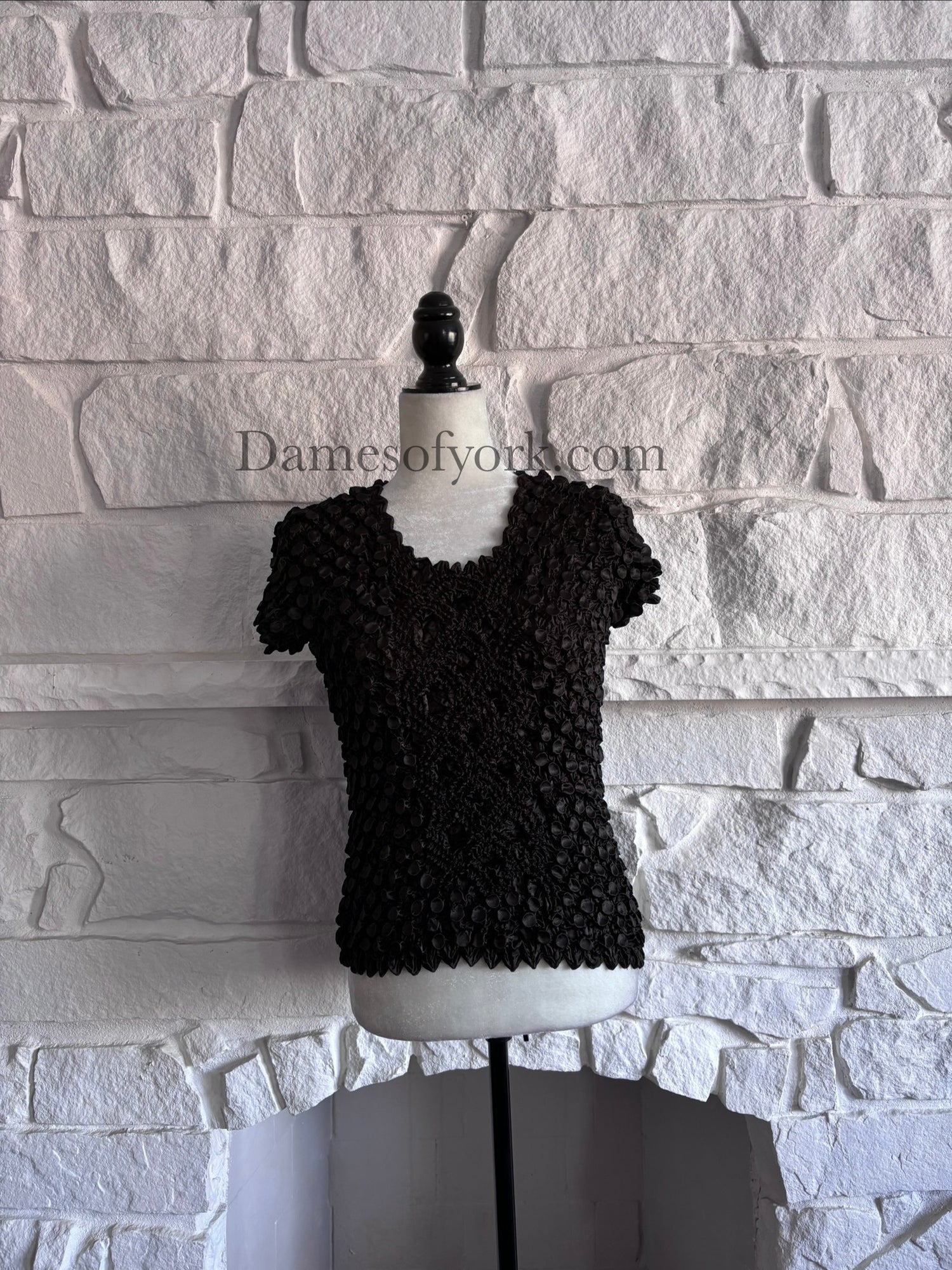 Front view of black crinkle texture top on mannequin with tentacle-like raised pattern