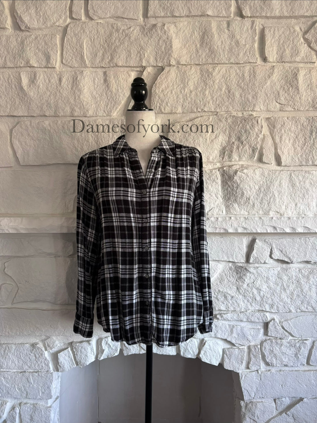 Front view of black and white plaid long sleeve shirt on mannequin with button-up closure