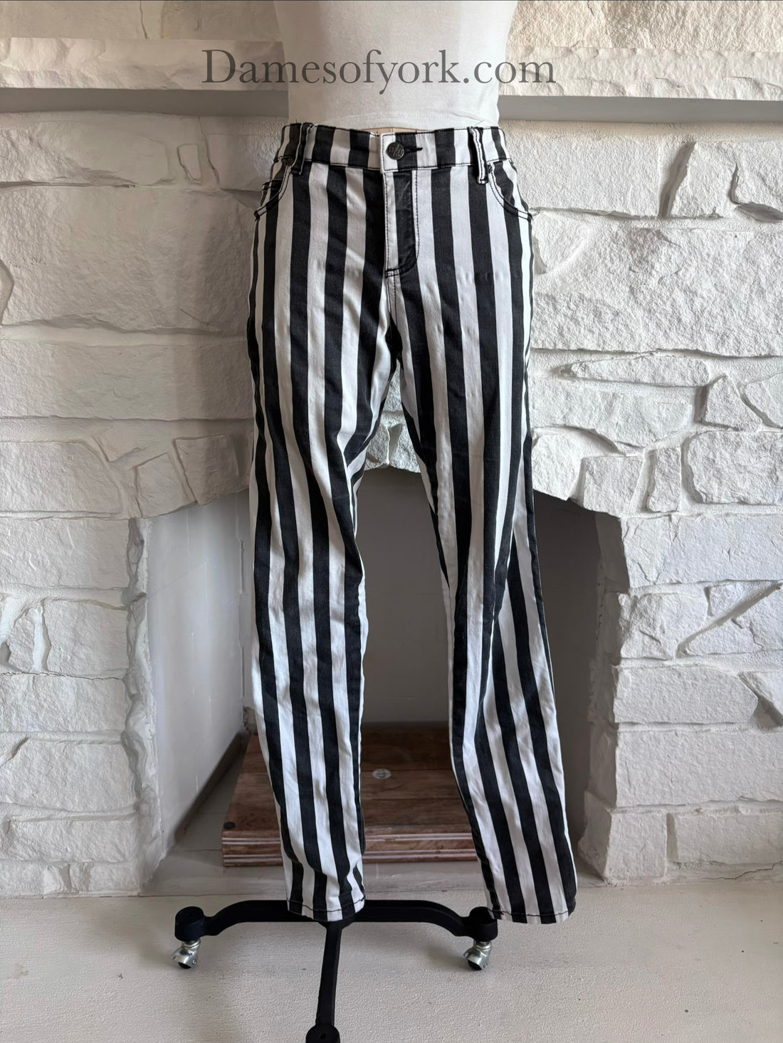 Front view of black and white vertical striped skinny jeans on mannequin