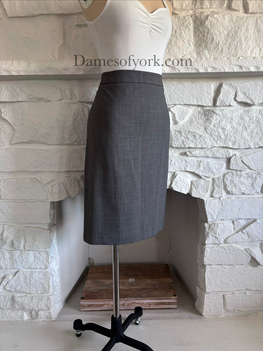 Diagonal view of grey corporate goth pencil skirt on mannequin showing tailored fit