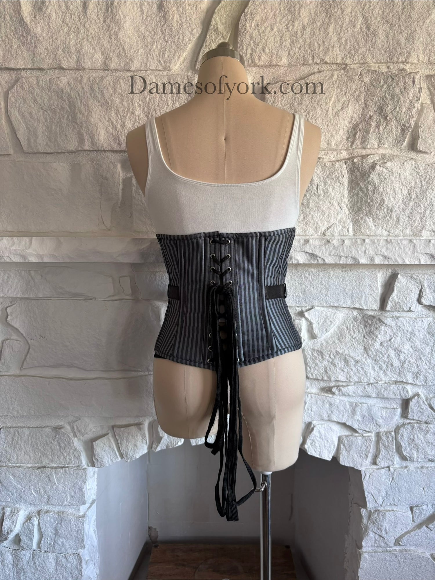 Back view of underbust corset on mannequin with lace-up closure