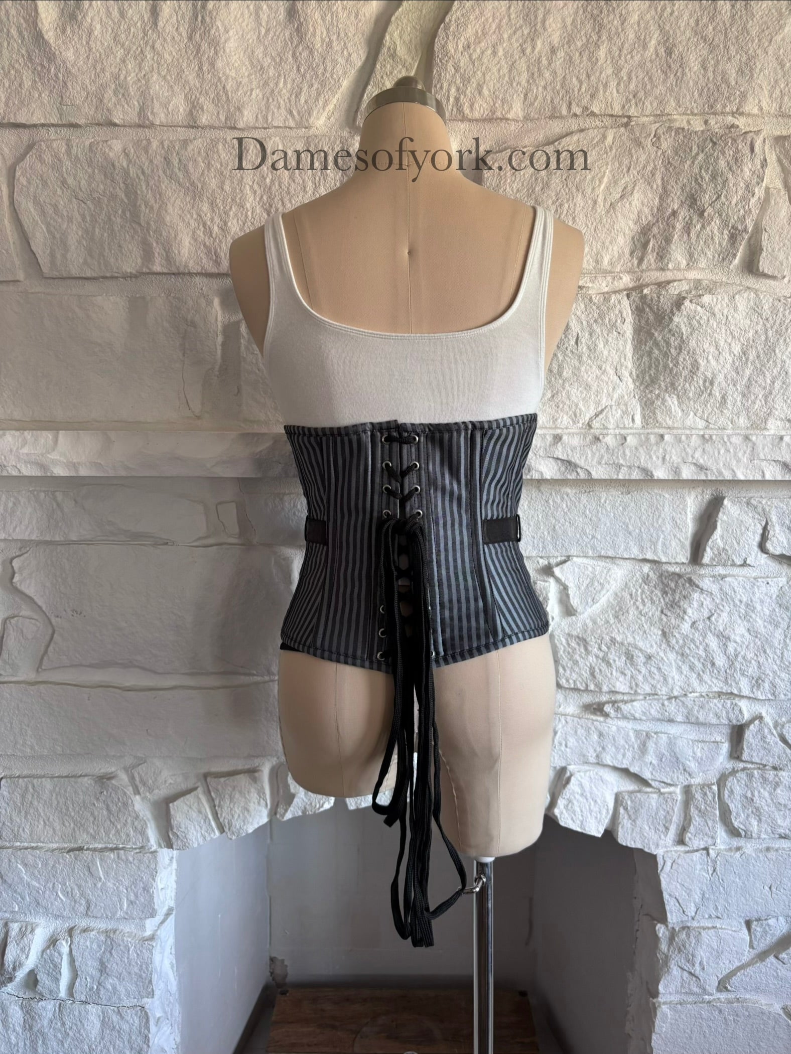 Back view of underbust corset on mannequin with lace-up closure