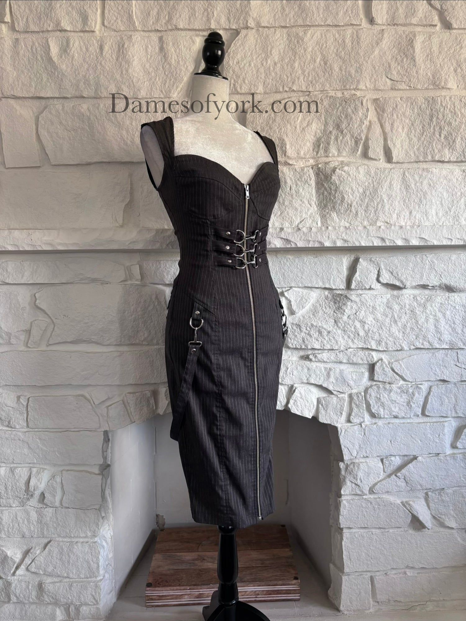 Diagonal view of industrial goth pencil dress on mannequin showing buckle waist details