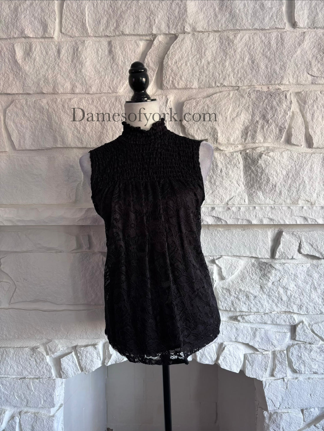 Front view of the Nocturne Lace Blouse, a sleeveless black blouse with lace overlay and a Victorian-inspired high neckline with frilled edge.