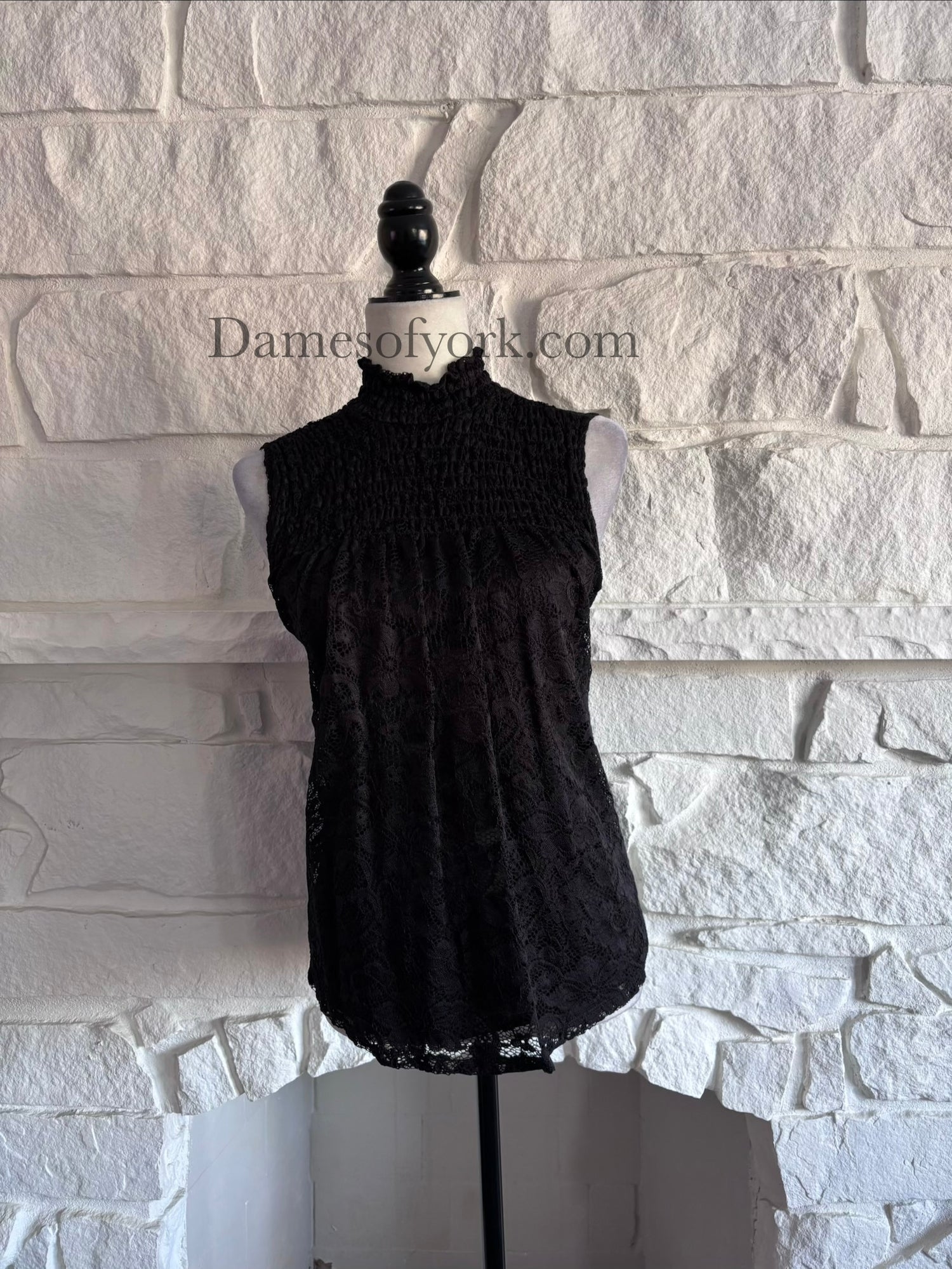 Front view of the Nocturne Lace Blouse, a sleeveless black blouse with lace overlay and a Victorian-inspired high neckline with frilled edge.