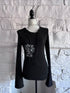 Front view of the Webbed Phantom Sweatshirt, a black knit sweatshirt with flared sleeves and a spiderweb graphic with an abstract figure on the front.