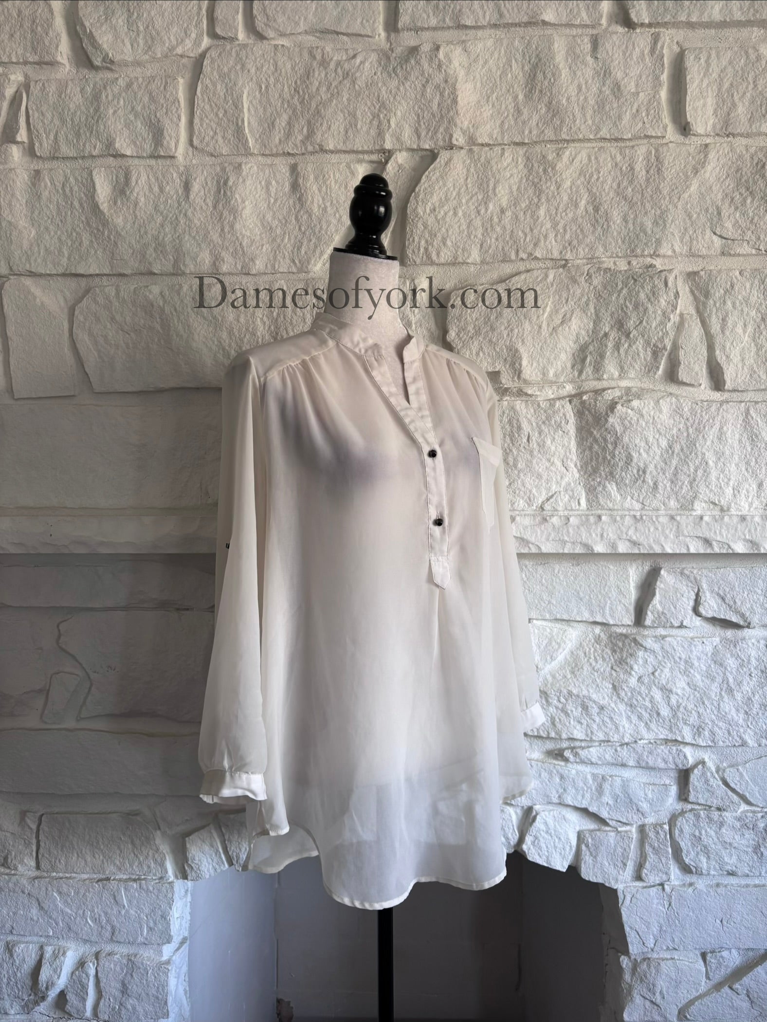 Diagonal view of ivory sheer blouse on mannequin showing soft drape and silhouette