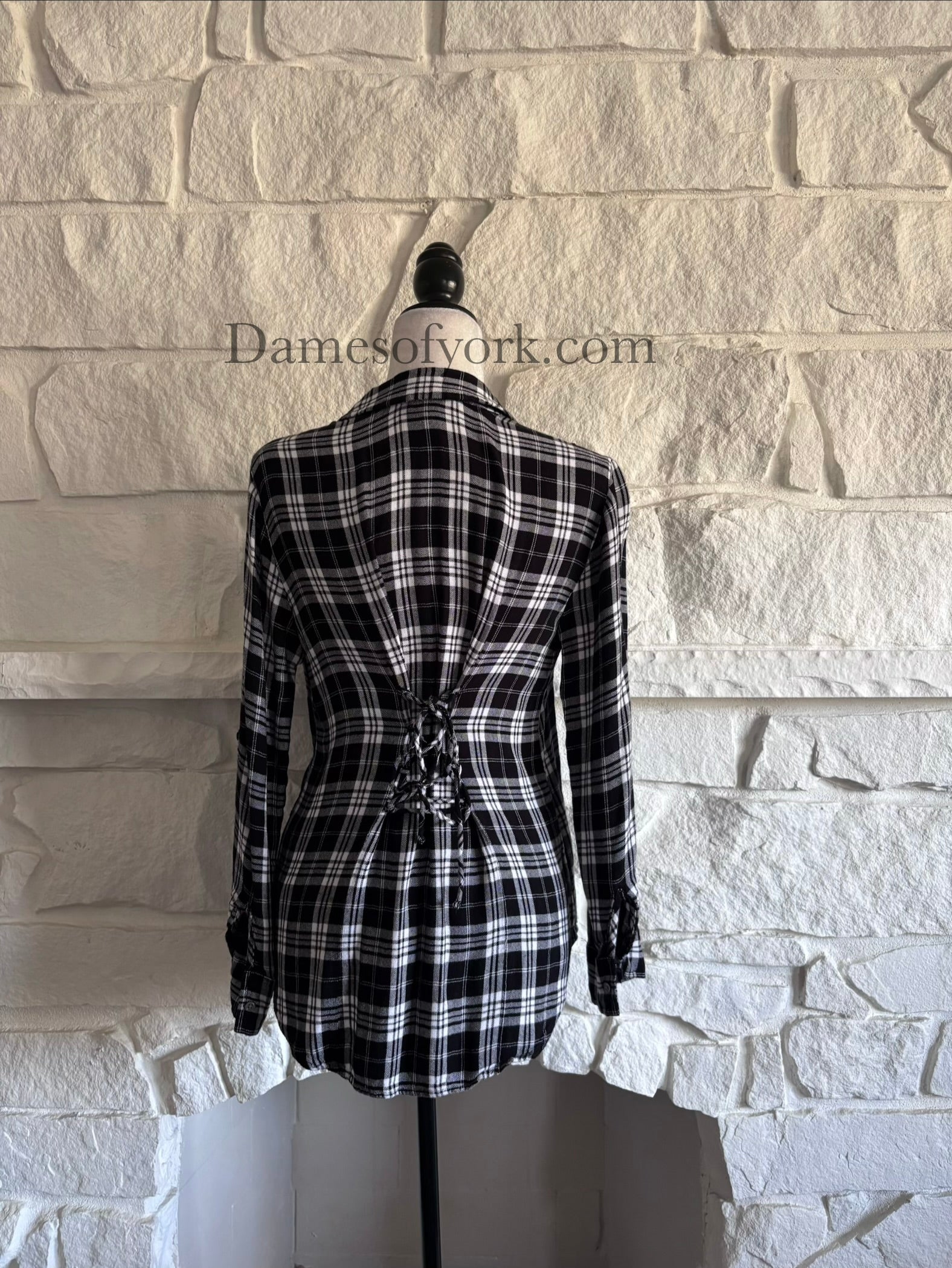 Back view of plaid long sleeve shirt on mannequin with adjustable lace-up waist for a flattering fit.