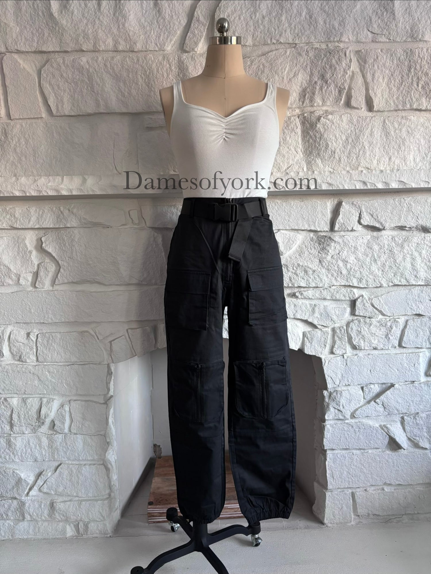 Front view of the Utility Lock Cargo Pants, black cargo pants with four large front pockets and a built-in belt with a click buckle.
