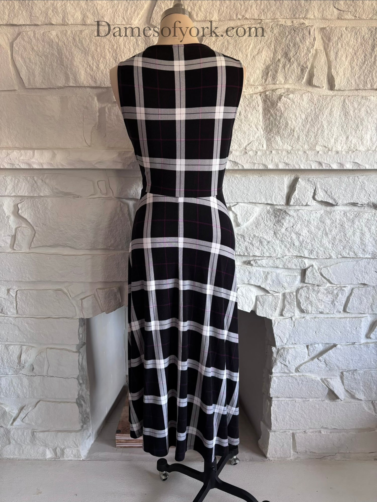 Back view of plaid dress on mannequin with smooth fitted back and flared hem