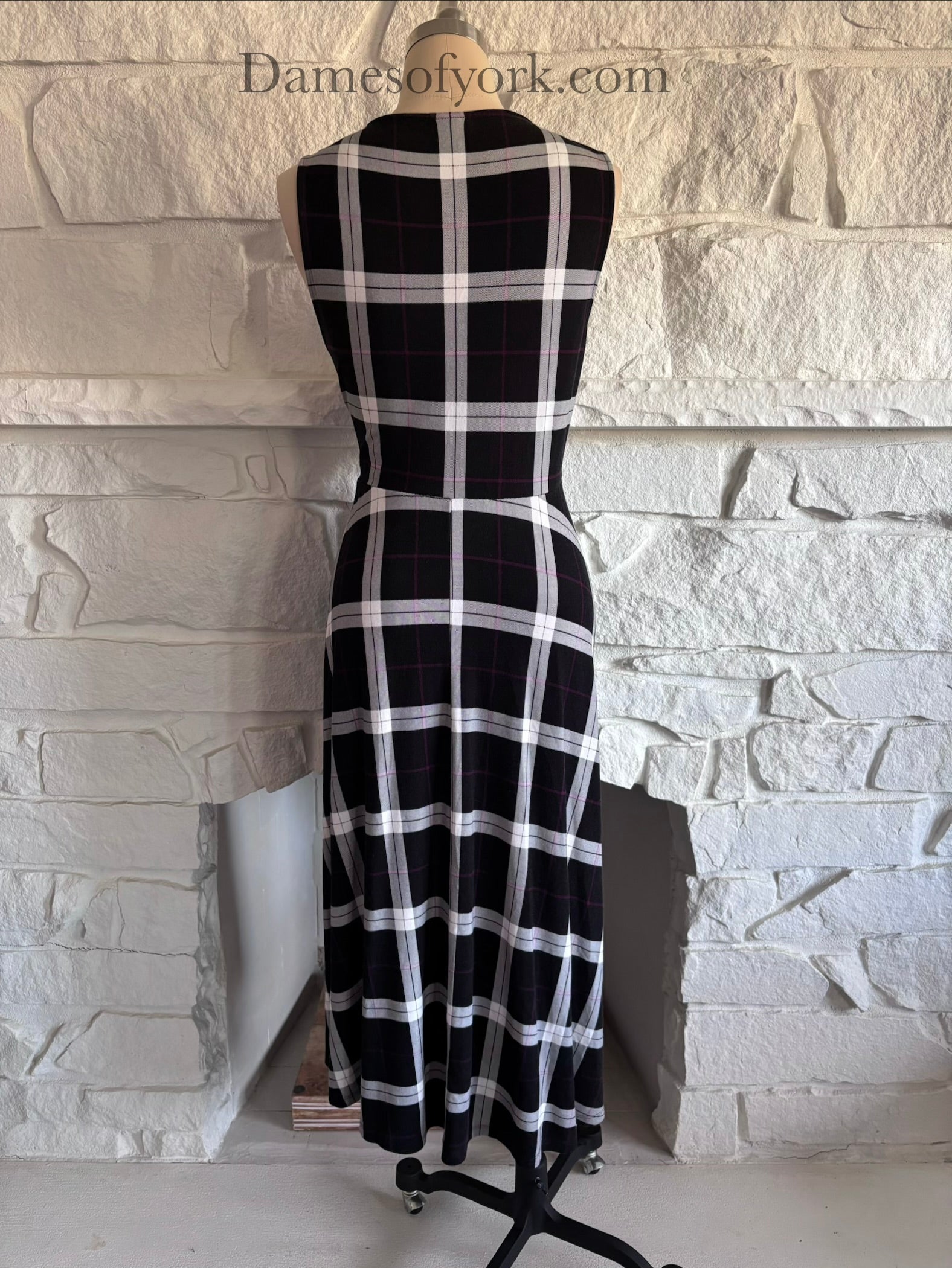 Back view of plaid dress on mannequin with smooth fitted back and flared hem