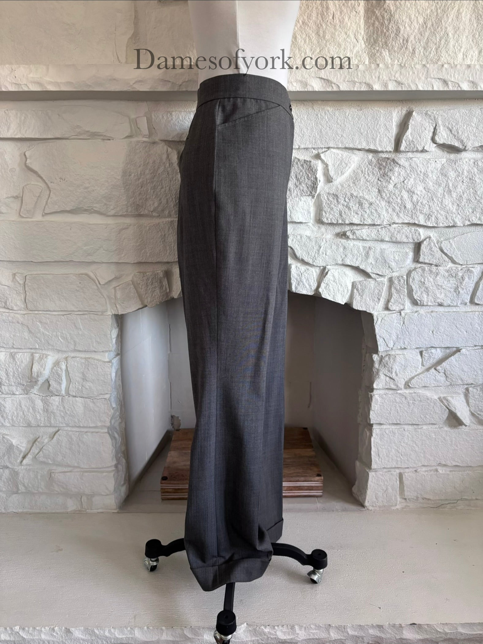 Side view of tailored grey trousers on mannequin with clean structured lines
