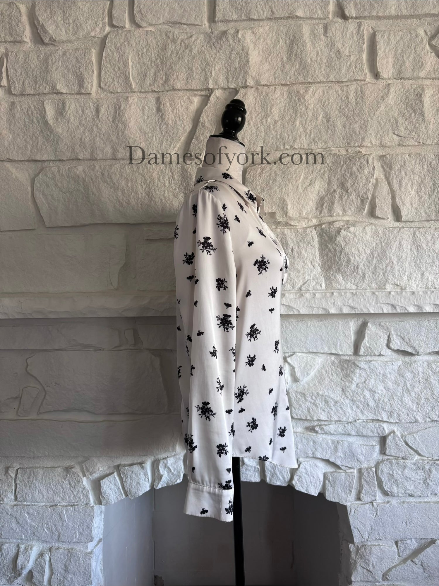 Side view of silky patterned blouse on mannequin with relaxed fit