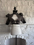 Front view of grey plaid Victorian goth bolero on mannequin with black ruffle collar and buckle details