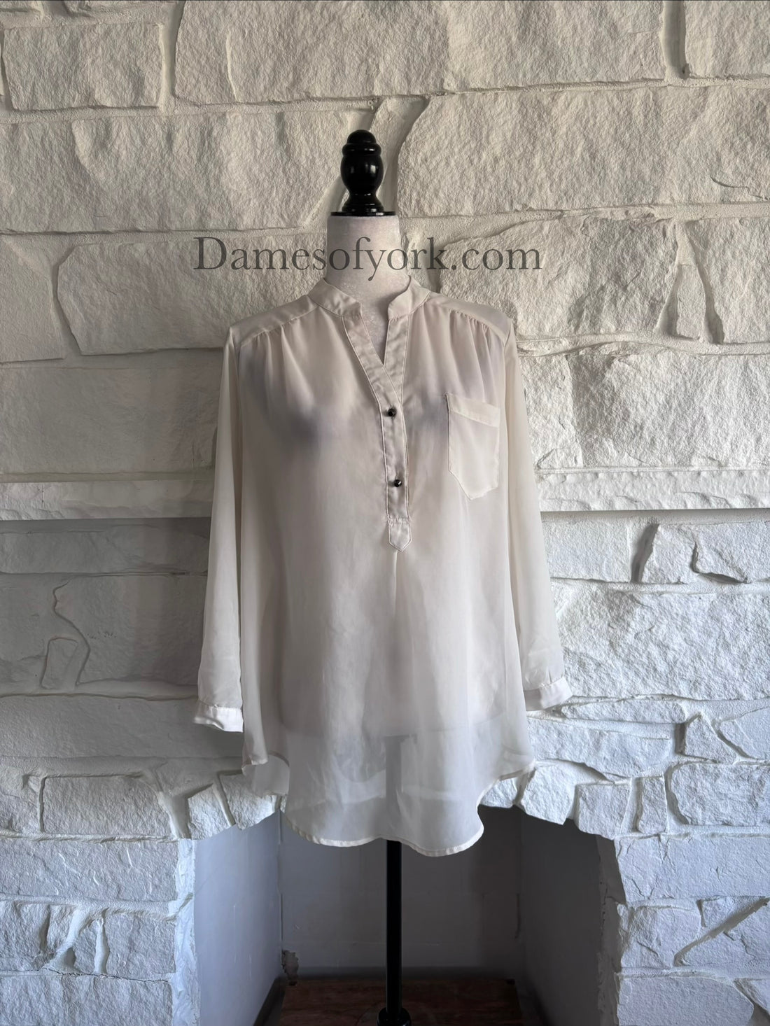 Front view of sheer cream V-neck blouse on mannequin with relaxed lightweight fit
