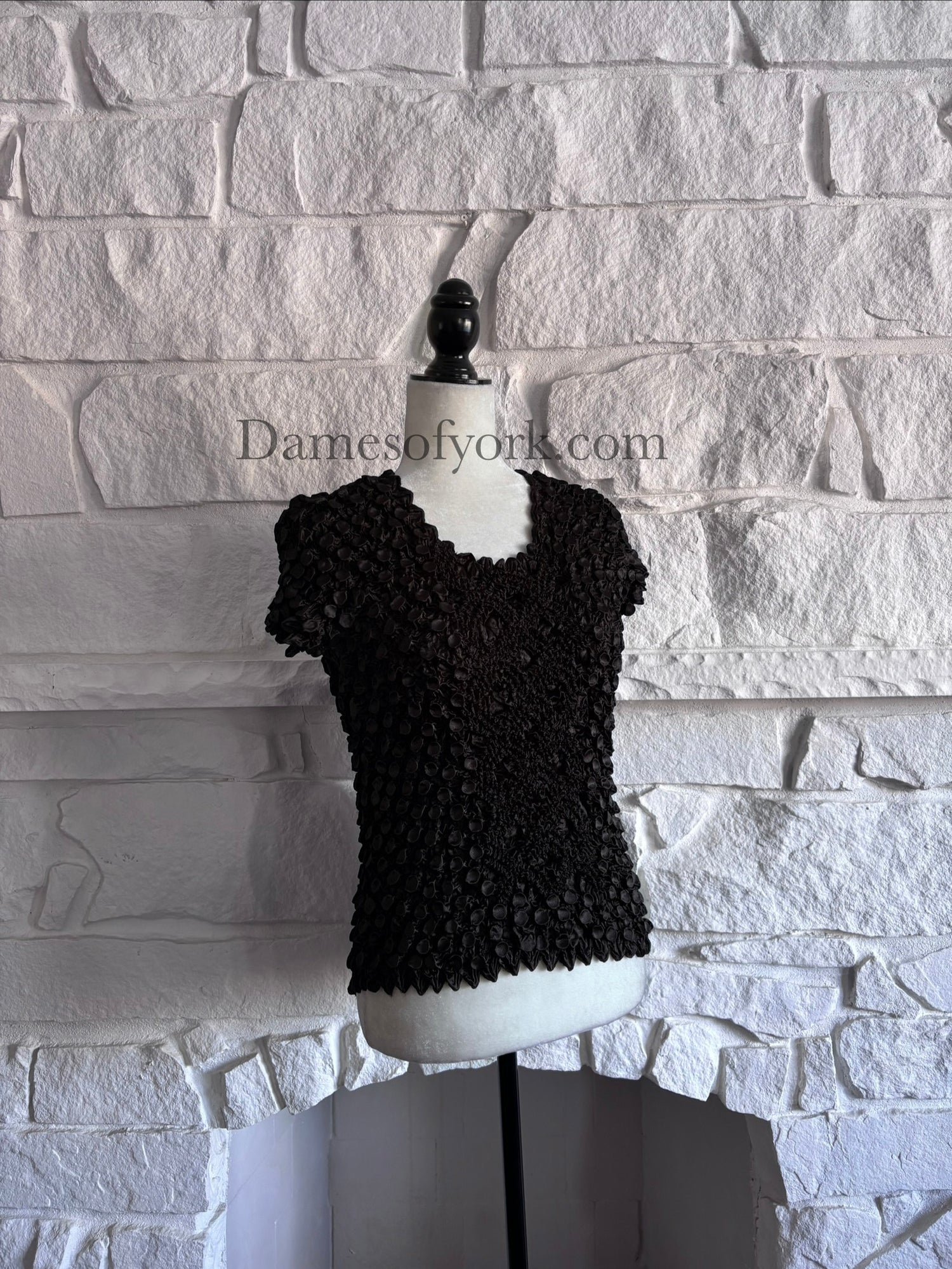 Diagonal view of fitted black Y2K crinkle top on mannequin showing mixed textures