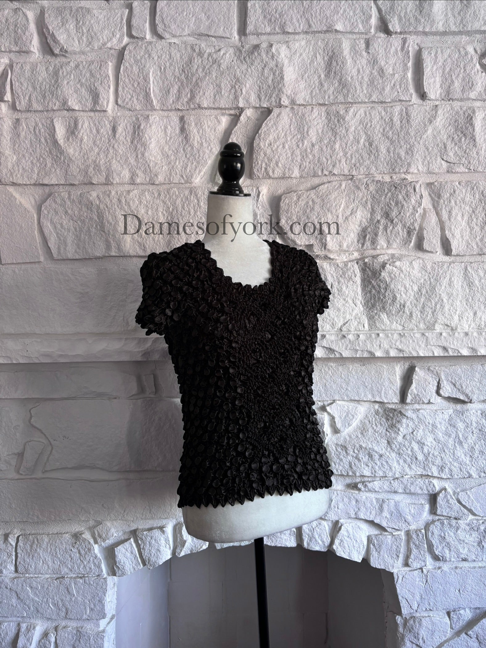 Diagonal view of fitted black Y2K crinkle top on mannequin showing mixed textures
