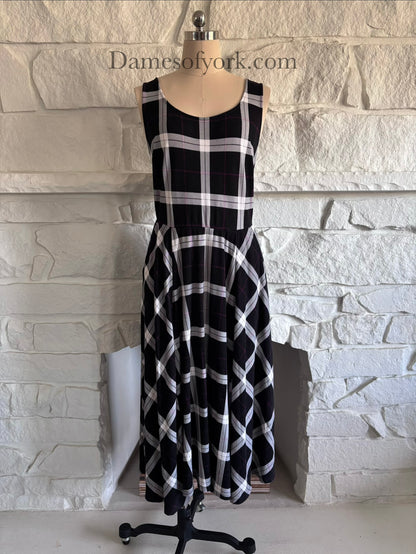 Front view of black white and purple plaid dress on mannequin with fitted bodice and flared skirt