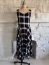 Front view of black white and purple plaid dress on mannequin with fitted bodice and flared skirt