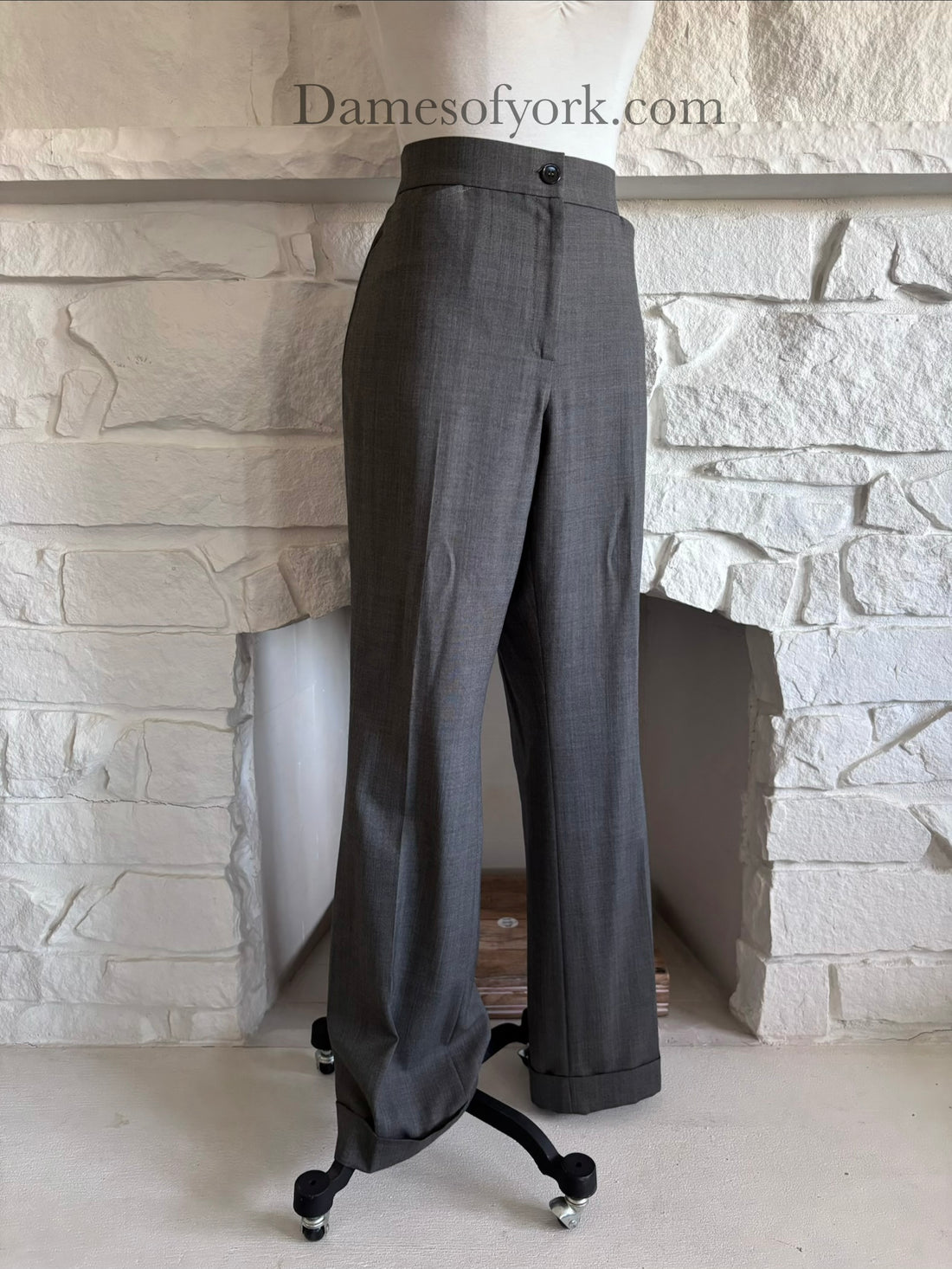 Diagonal view of grey corporate goth dress pants on mannequin showing straight leg silhouette