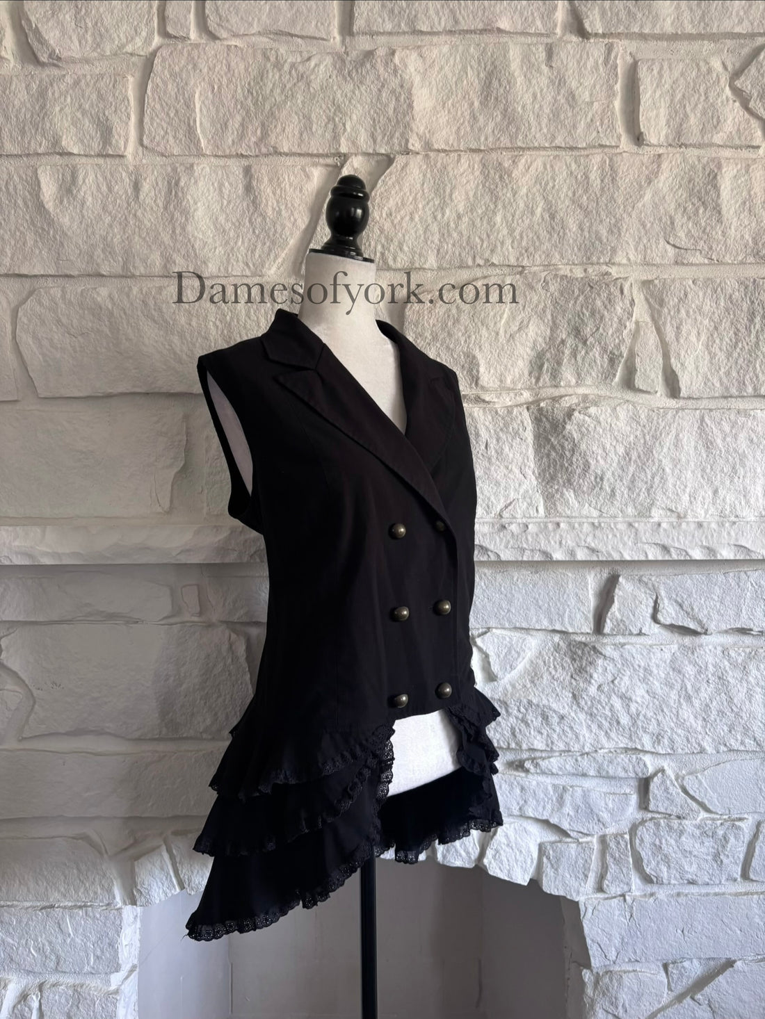 Diagonal view of fitted gothic vest on mannequin showing lace details and hi-low silhouette