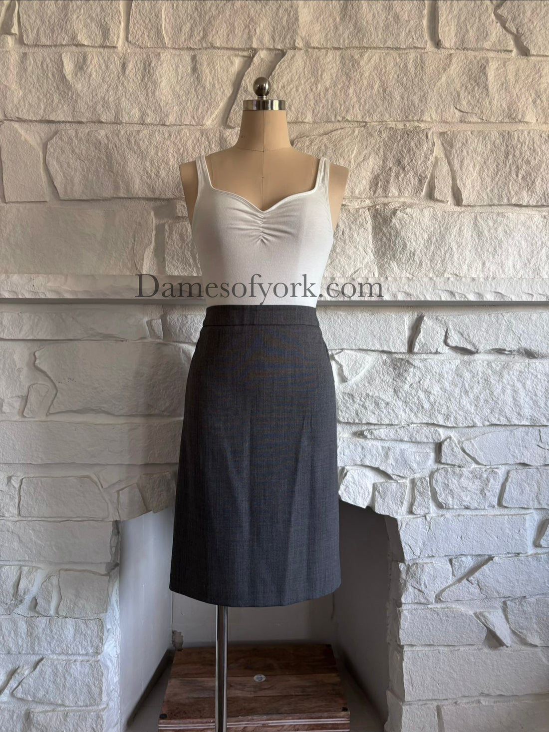 Front view of fitted grey pencil skirt on mannequin with streamlined silhouette