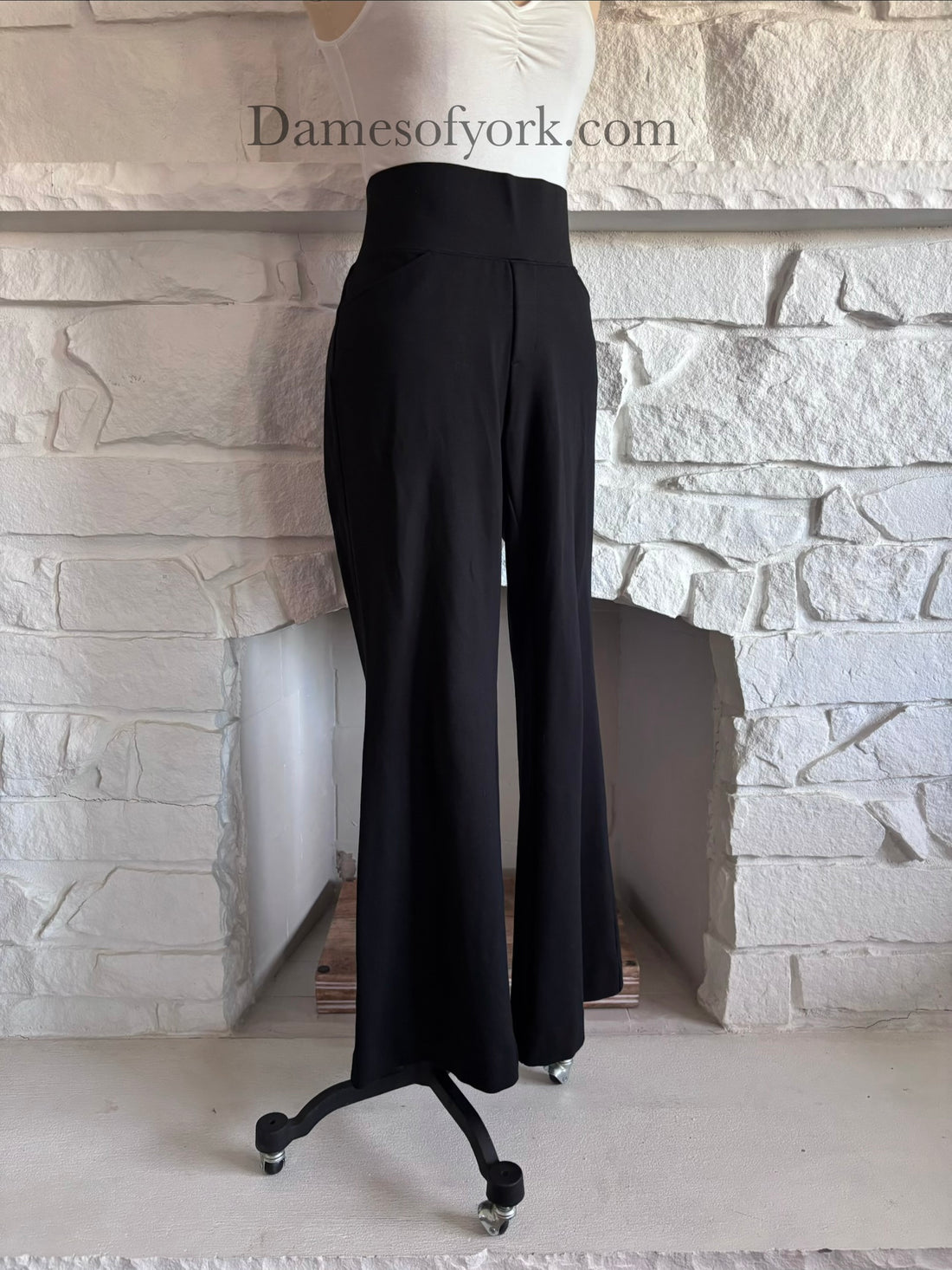 Diagonal view of wide leg black pants on mannequin showing relaxed fit silhouette