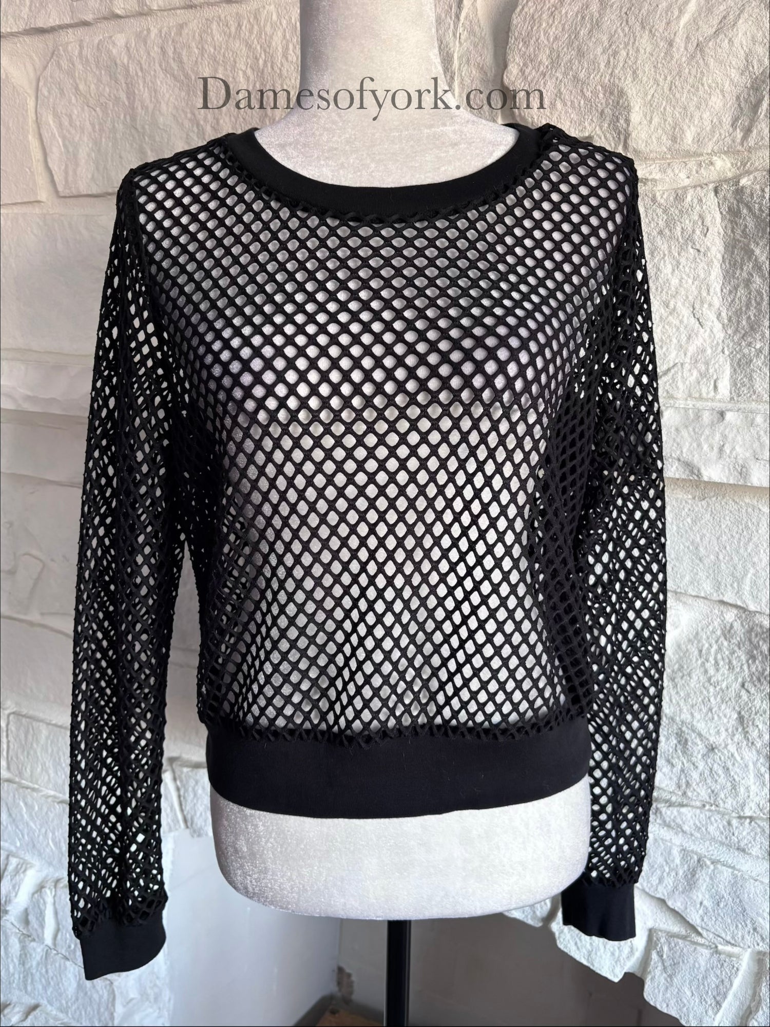 Close-up detail of the Nightveil Mesh Top featuring the wide mesh fabric and ribbed banded hem.