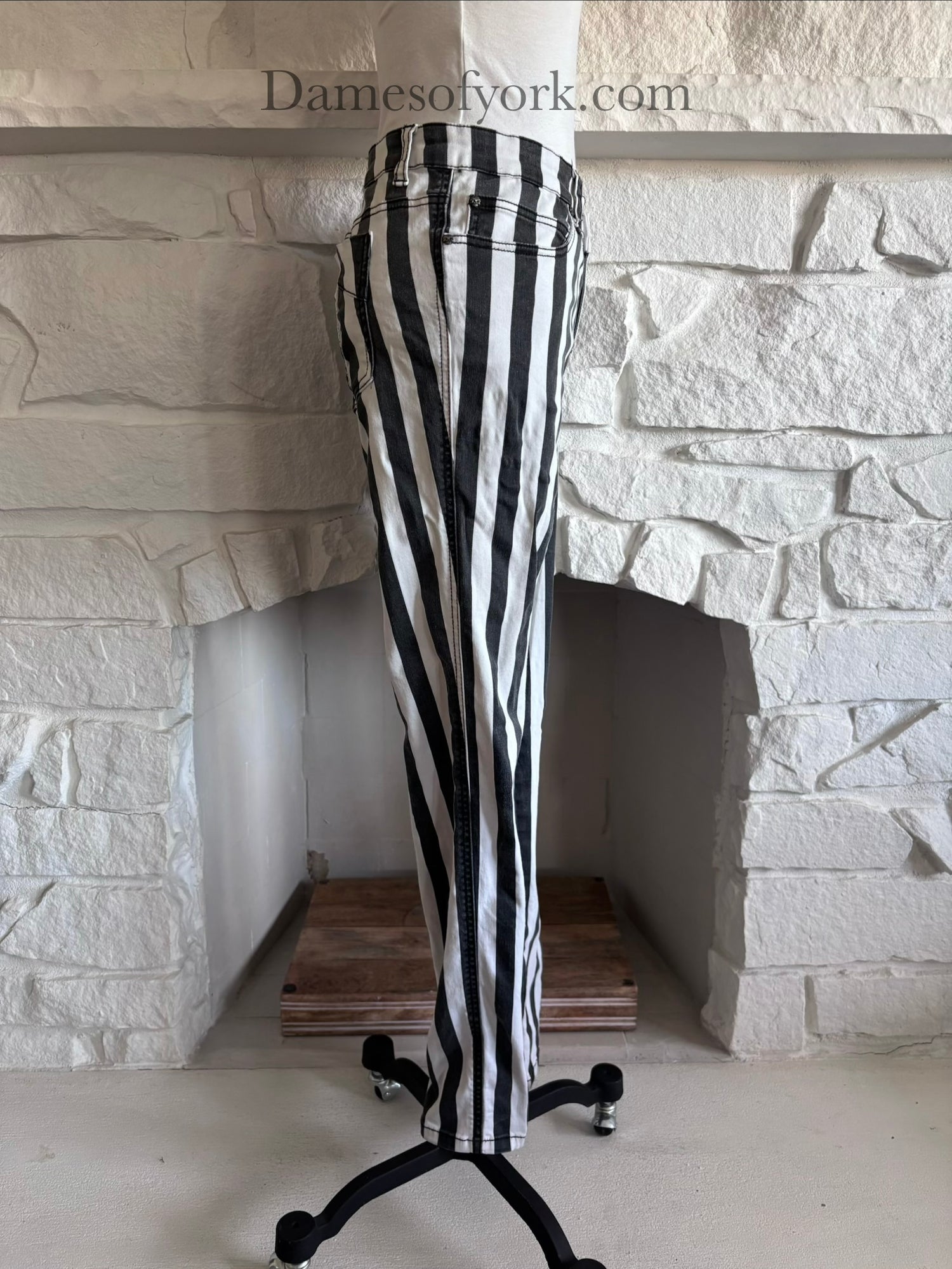 Side view of black and white striped jeans on mannequin with slim leg fit