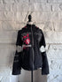 Front view of the Stray Voltage Hoodie, a black punk hoodie with red plaid lined cat ear hood, front zipper, decorative side lacing, and layered hardware details.