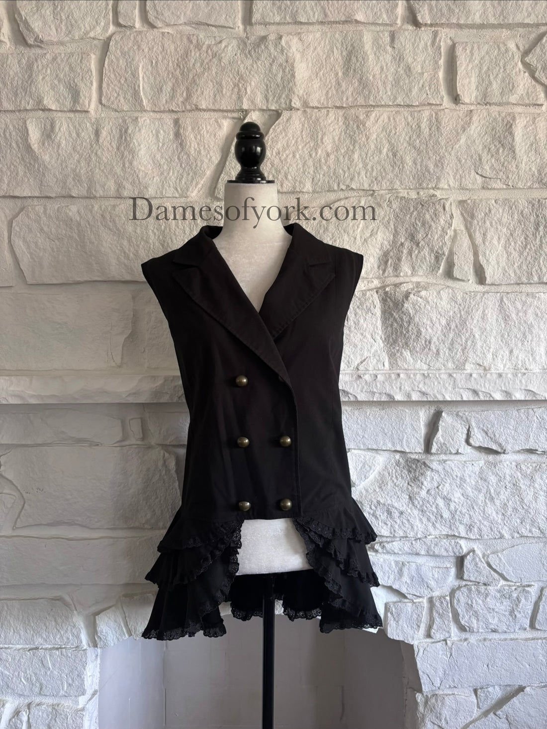 Front view of black Victorian goth vest on mannequin with double-breasted buttons and ruffle hem