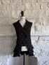 Front view of black Victorian goth vest on mannequin with double-breasted buttons and ruffle hem