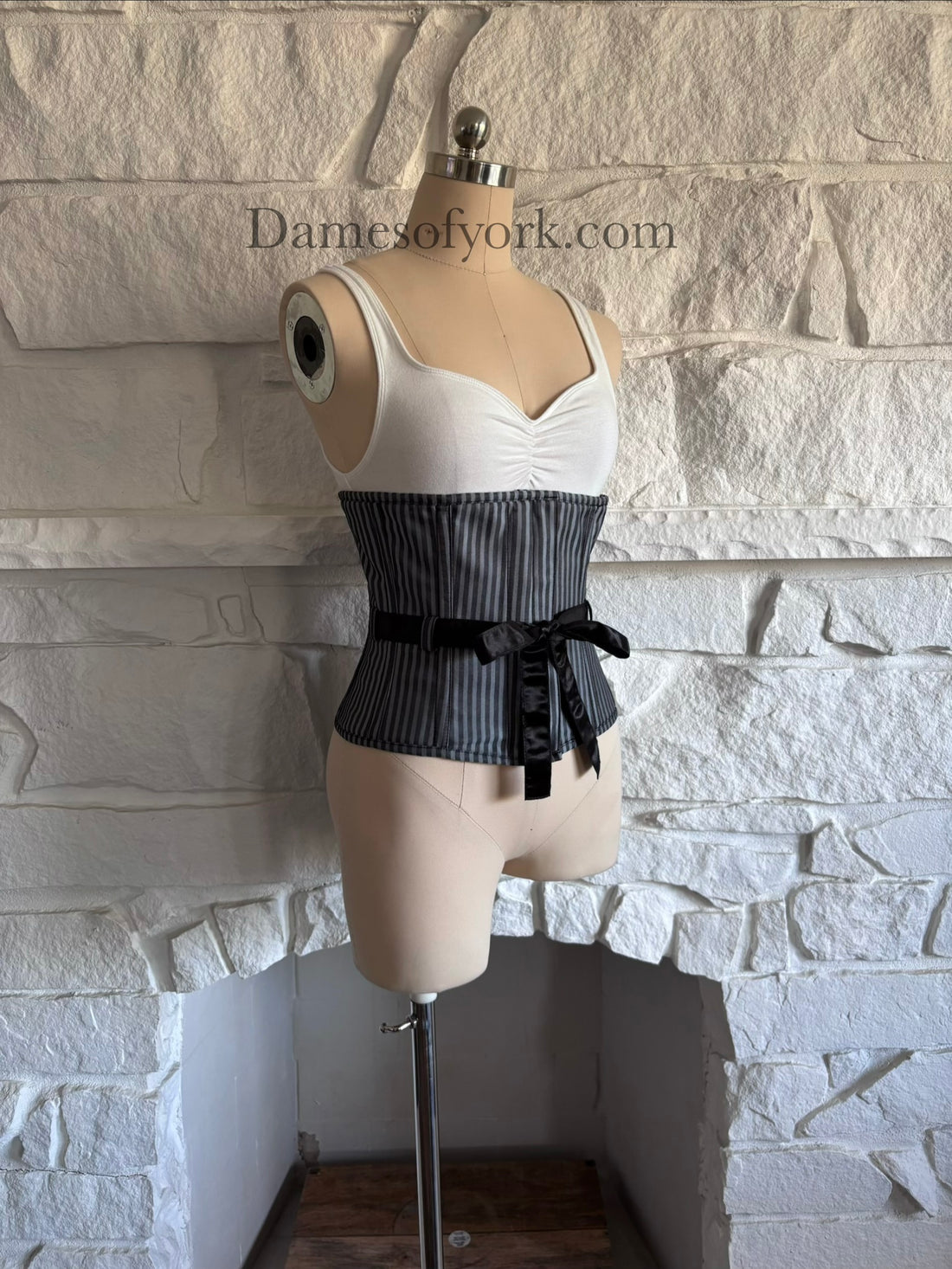 Diagonal view of gothic underbust corset on mannequin showing structured shaping and vertical stripes