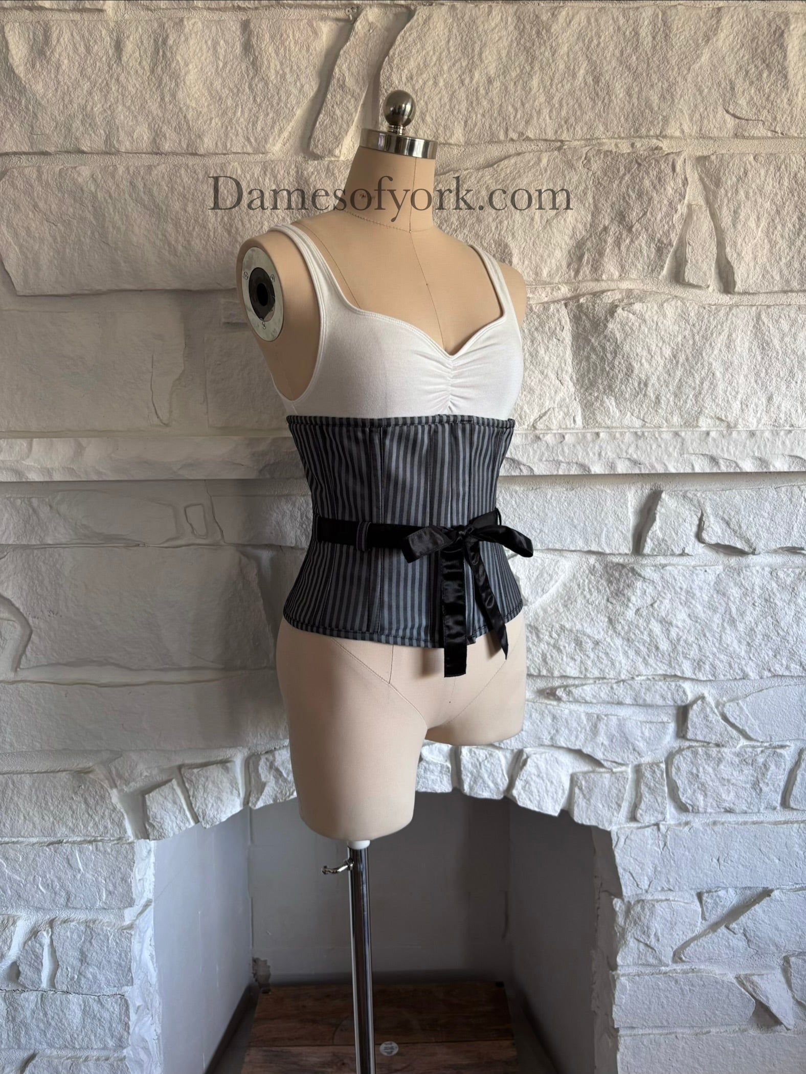Diagonal view of gothic underbust corset on mannequin showing structured shaping and vertical stripes