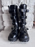 Front view of the Rivet Command Boots, mid-calf black industrial boots with multiple buckle straps and metal grommets.