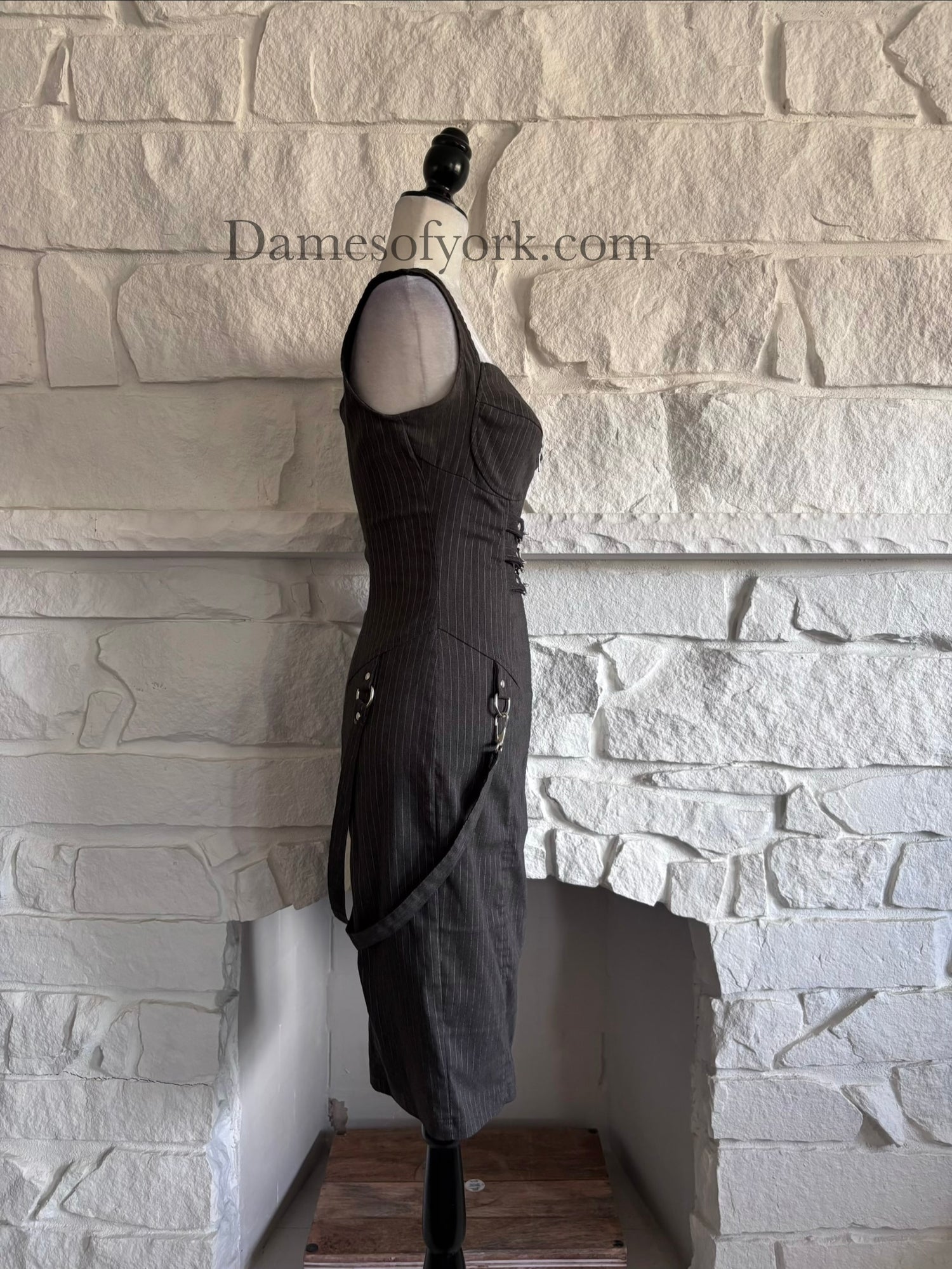 Side view of sleeveless pinstripe bodycon dress on mannequin with fitted silhouette