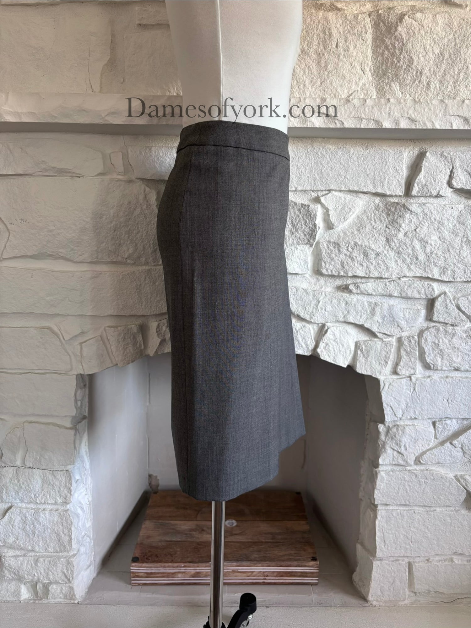 Side view of fitted grey midi skirt on mannequin with sleek shape