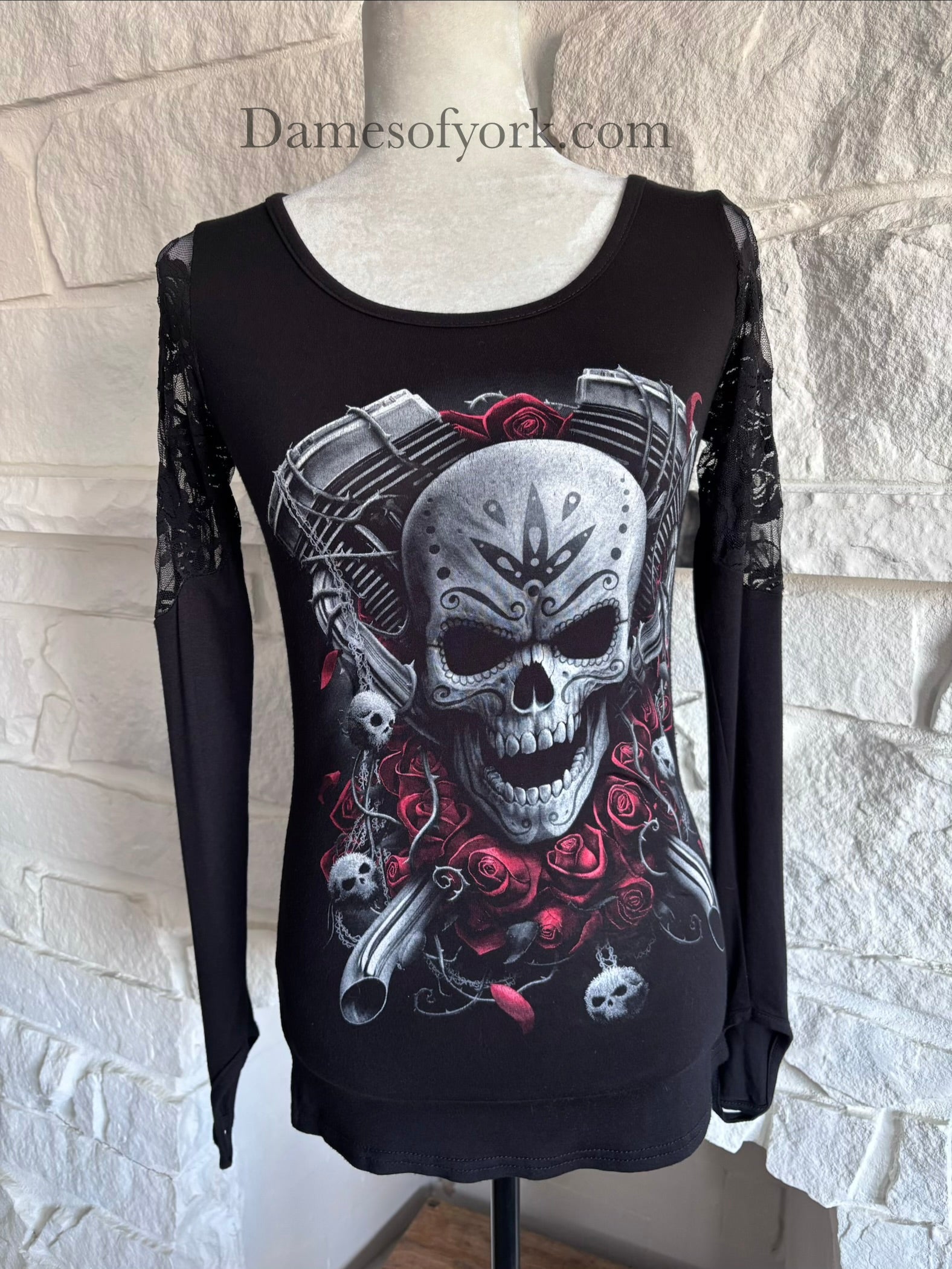 Close-up detail of the Graveyard Radio Top featuring the skull and microphone graphic with red rose accents and lace sleeve texture.