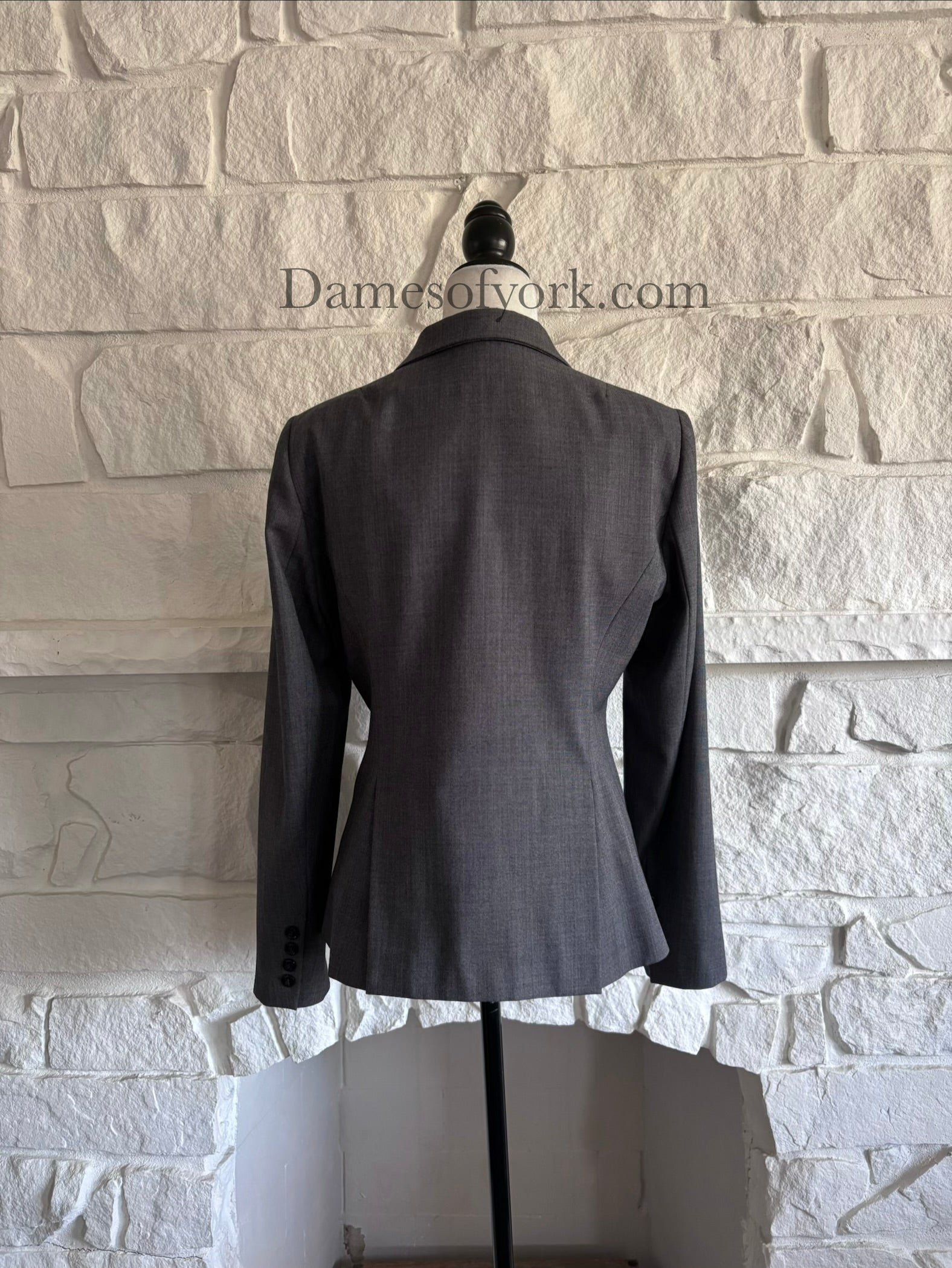 Back view of grey business style blazer on mannequin with tailored fit