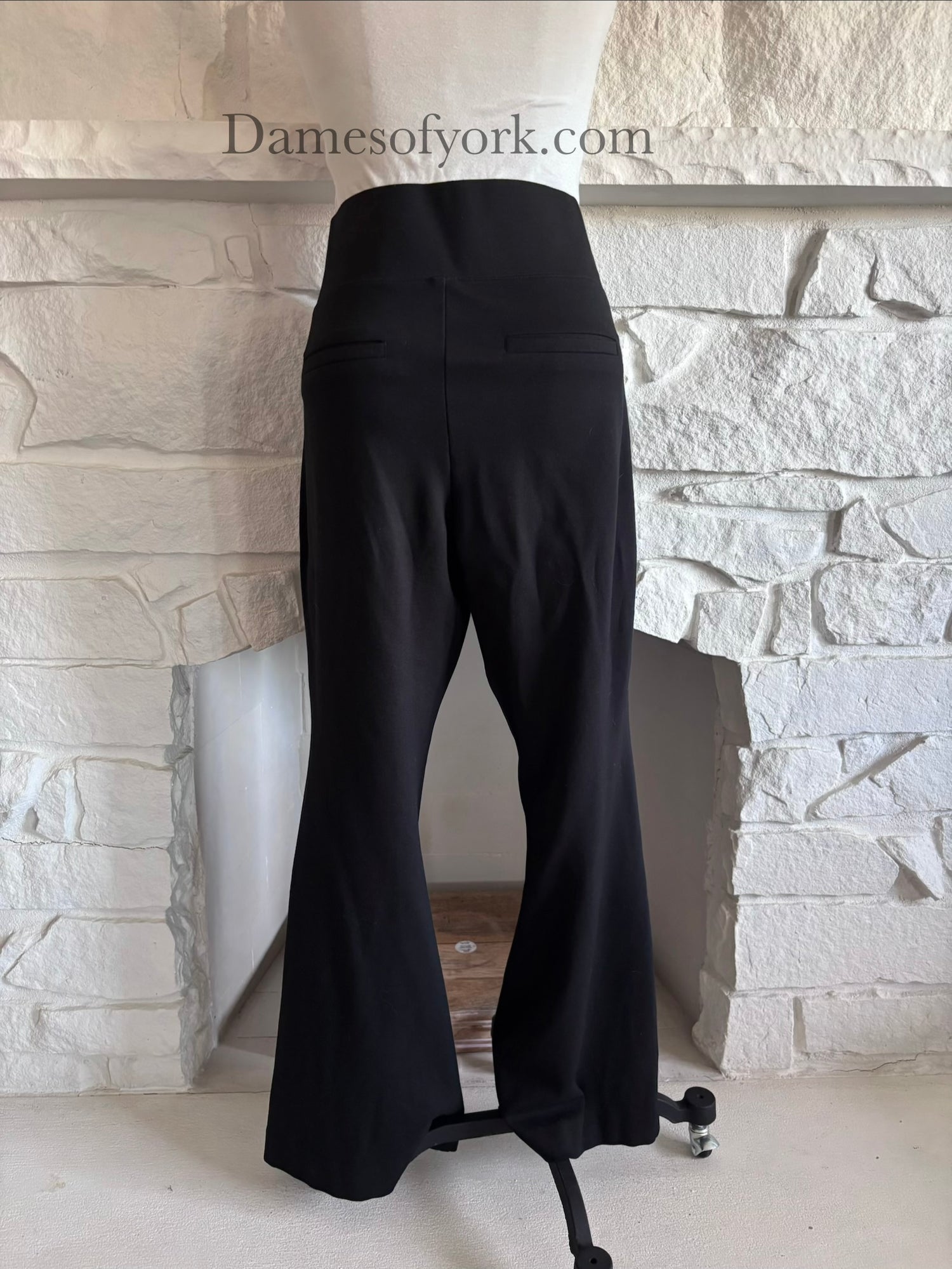 Back view of black wide leg trousers on mannequin with decorative back pockets