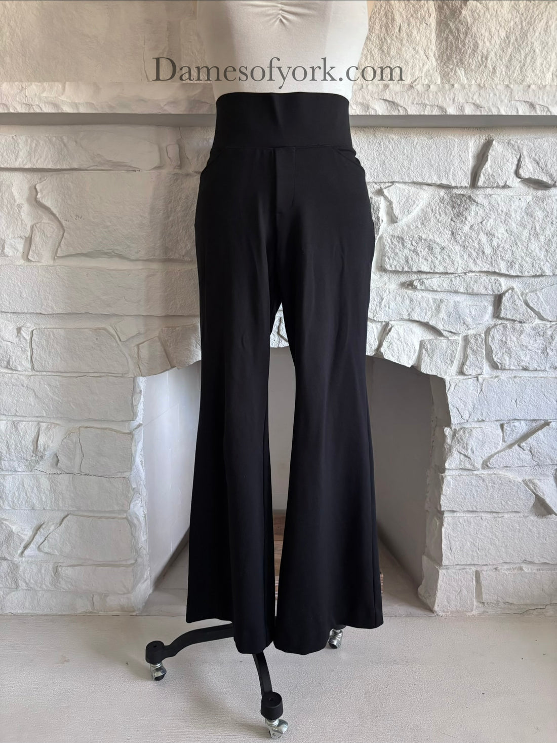 Front view of black wide leg trousers on mannequin with elastic waistband and pockets