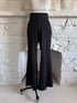 Front view of black wide leg trousers on mannequin with elastic waistband and pockets