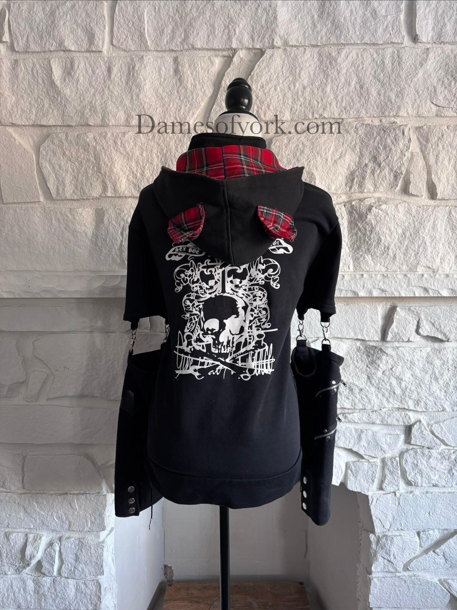 Back view of the Stray Voltage Hoodie showing the detachable hood with red plaid lining and cat ears with the hood down.