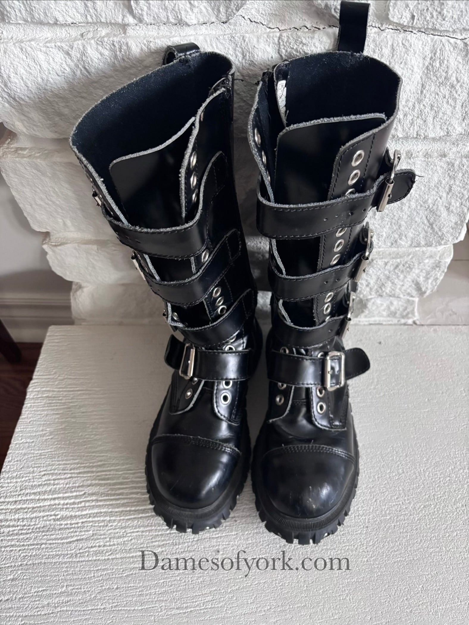 Top front view of the Rivet Command Boots, mid-calf black industrial boots with multiple buckle straps and metal grommets.